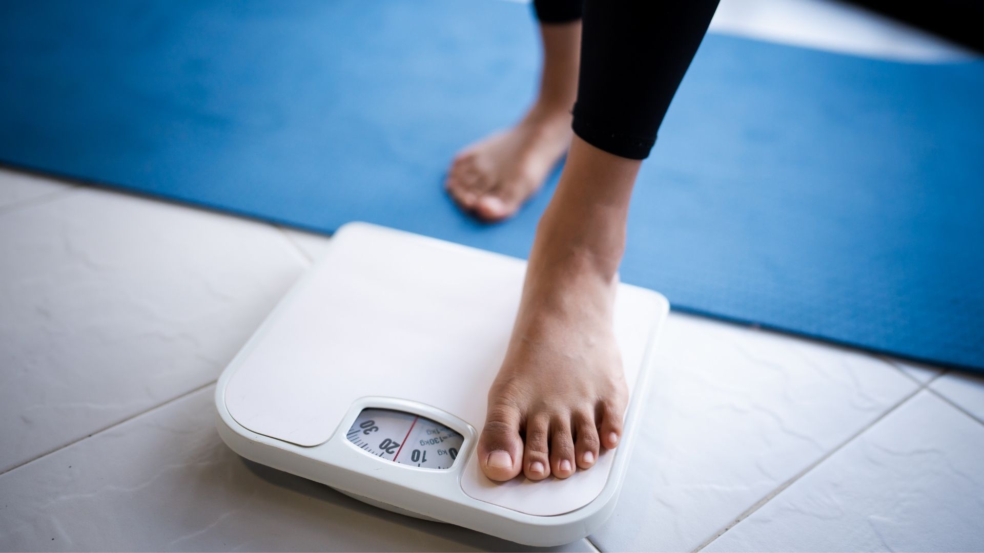 A woman on a bathroom scale.